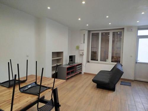 a living room with a black chair and a couch at F1 lumineux in Saint-Pourçain-sur-Sioule