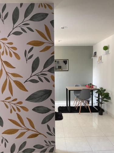 ein Esszimmer mit einem Wandbild aus Blättern in der Unterkunft Apartamento moderno cerca al aeropuerto in Neiva