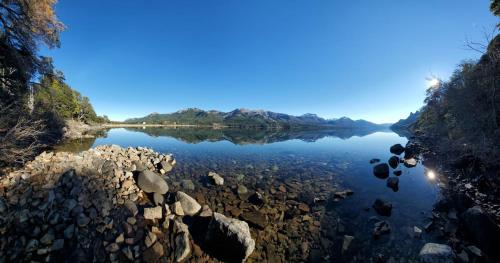 a view of a river with rocks in the water at La Torre del Lago in Villa Meliquina