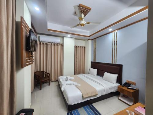 1 dormitorio con 1 cama grande y ventilador de techo en Hotel S.A International, en Cox's Bazar