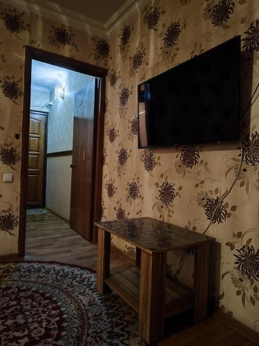 a living room with a television on the wall at Квартира 2х комнатная in Shymkent