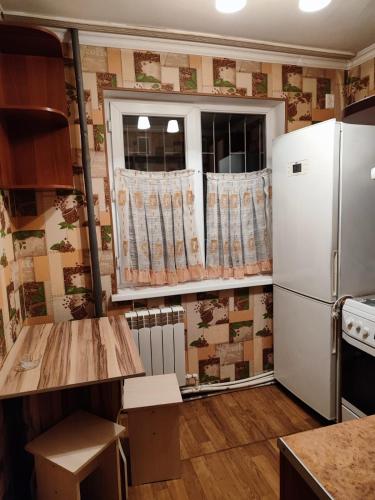 a kitchen with a refrigerator and a window at Квартира 2х комнатная in Shymkent