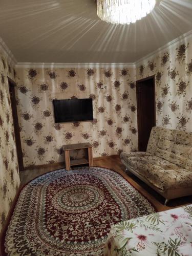 a bedroom with a bed and a tv on the wall at Квартира 2х комнатная in Shymkent