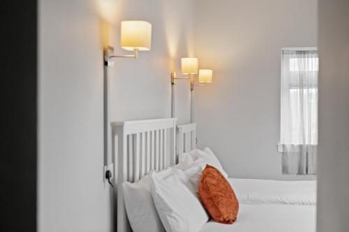 a bedroom with two beds and two lights on the wall at Queensferry Guest house in Rosyth
