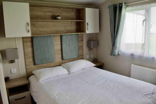 a bedroom with a white bed and a window at Scottish Holiday Home in Ardeer Square