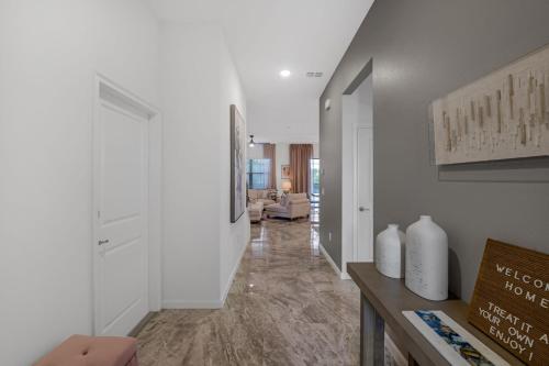um corredor com paredes brancas e uma sala de estar em Orlando's Best Escape Residence at Paradiso Grande Resort home em Orlando