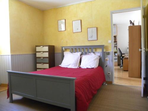 a bedroom with a bed with red sheets and white pillows at Domaine de Pré Rond in La Faurie