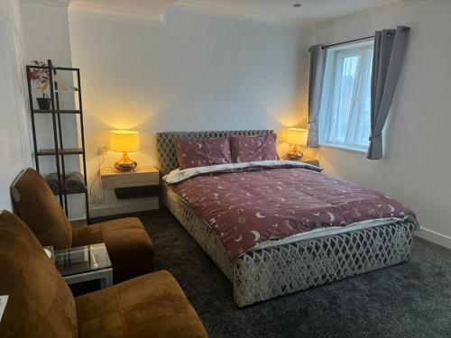 een slaapkamer met een bed, een bank en een raam bij Luton Lodge - Near London Luton Airport Luxury Quite Rooms Close to Restaurants & Shops in Luton