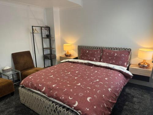 a bedroom with a bed and a chair and two lamps at Luton Lodge - Near London Luton Airport Luxury Quite Rooms Close to Restaurants & Shops in Luton