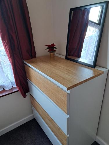 a dresser with a mirror on top of it at Nina's Cozy Lodge in Wigan