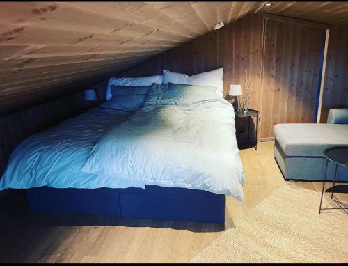 a large bed in a bedroom with a wooden ceiling at Beitostølen-Sørliestølen -Nyrenovert hytte 2022 på Slettefjell in Vevle