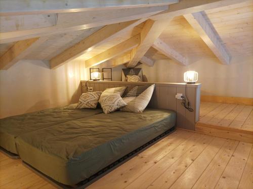 un grand lit dans une chambre avec parquet dans l'établissement casasantellix, à Prunelli-di-Fiumorbo