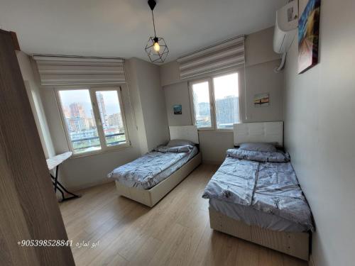 two beds in a room with two windows at Apartment in Bursa - Turkey in Bursa