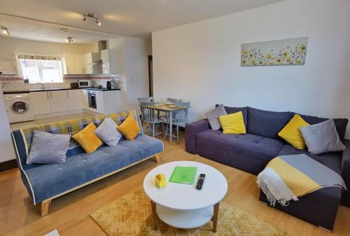 a living room with a blue couch and a table at Spacious 2 Bedroom Apartment, 3 Bathrooms,Parking,Sleeps 6,SO15 in Southampton
