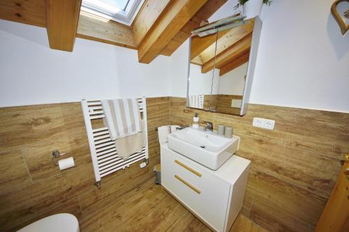 ein Badezimmer mit einem weißen Waschbecken und einem Spiegel in der Unterkunft Ferienwohnung Johannesklause in Mittenwald