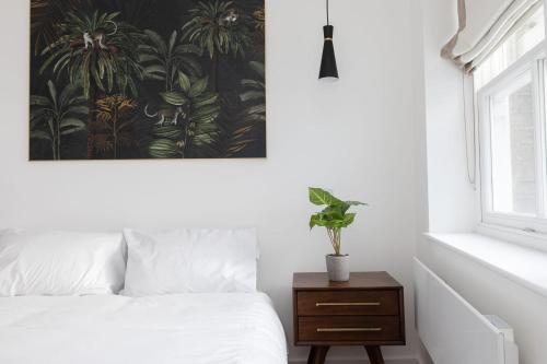 a bedroom with a bed and a painting on the wall at Luxury 2 Bedroom Duplex Penthouse Covent Garden Holborn in London