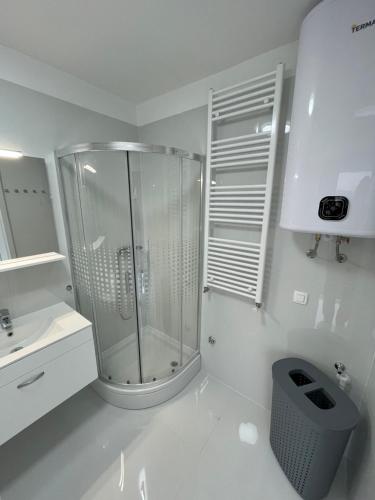 a white bathroom with a shower and a sink at Apartment White Zagreb - private parking&garage in Zagreb