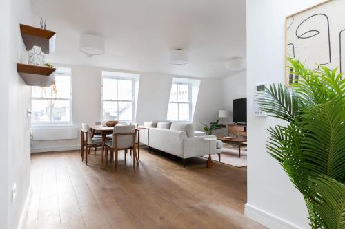a living room with a table and a couch at Luxury 2 Bedroom Duplex Penthouse Covent Garden Holborn in London