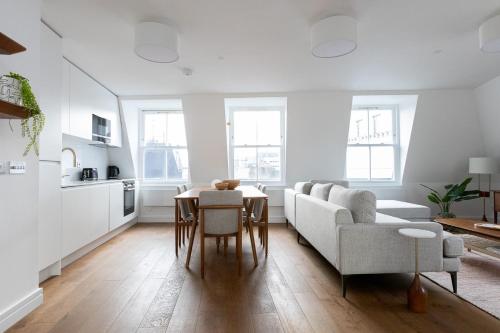 a living room with a couch and a table at Luxury 2 Bedroom Duplex Penthouse Covent Garden Holborn in London