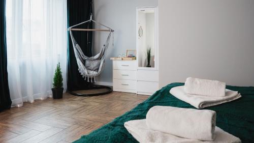 a bedroom with a hammock and a green blanket at Całorocznik apartamenty in Ryczów