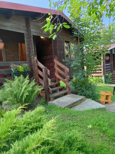 una casa con una escalera de madera delante de ella en DOMKI LETNISKOWE KOMAŃCZA, en Komańcza