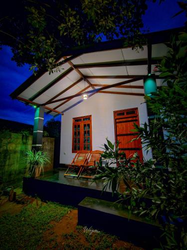 a small white house with awning at night at Wild Horizon in Udawalawe