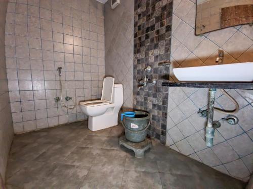 a bathroom with a toilet and a sink at KRL Inn in Mandvi