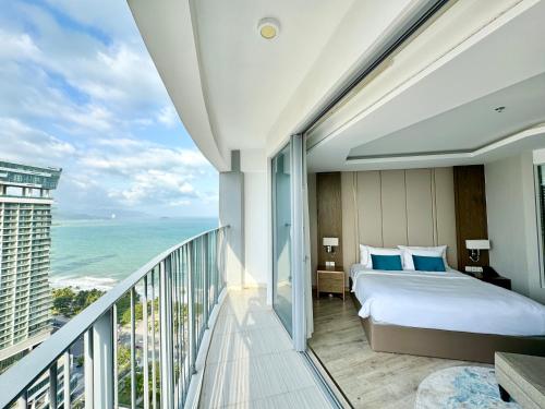 a bedroom with a bed and a balcony with the ocean at Panorama Luxury Beach Front Residences in Nha Trang