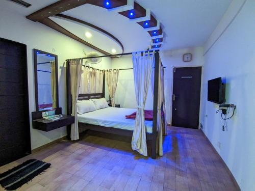 a bedroom with a bed and a tv in it at KRL Inn in Mandvi