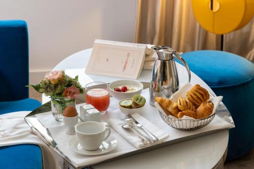 a tray of breakfast food on a table in a room at Hôtel Etoile Maillot in Paris