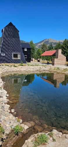 a reflection of a building in a body of water at La Torre del Lago in Villa Meliquina