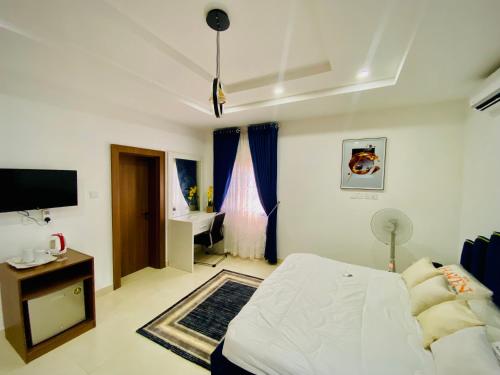 a bedroom with a bed and a desk and a television at Abuja Getaways in Abuja