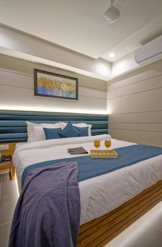 a bedroom with a large bed with blue accents at Hotel Lake Point in Ahmedabad