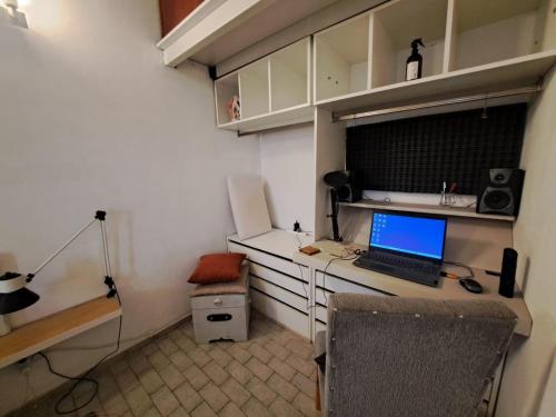 a room with a desk with a laptop computer on it at Cómodo departamento en el bajo neuquino in Neuquén
