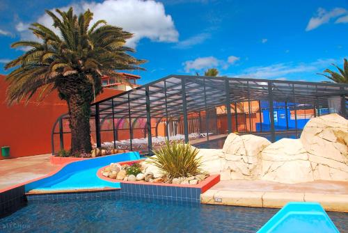 un complexe avec une piscine et un bâtiment dans l'établissement SOLEIL & PLAGE au CAMPING MAR ESTANG 4 ETOILES 3 chambres 2 salle de bain, à Canet