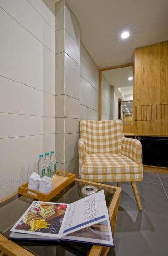 a living room with a chair and a table at Hotel Lake Point in Ahmedabad