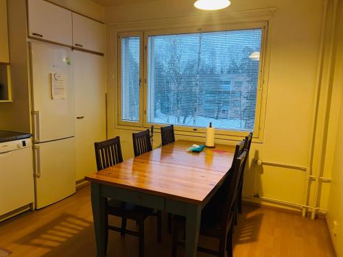 een keuken met een houten tafel en een groot raam bij Whole Apartment in Vantaa