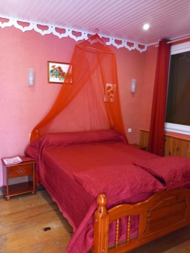 a bedroom with a red bed with a canopy at Villa Mancina in Capesterre-Belle-Eau
