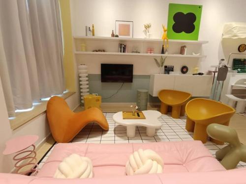 uma sala de estar com uma cama e cadeiras cor-de-rosa em Dopamine Decor New Unit Sunway Grid/4-6Pax/Netflix em Kampong Pendas