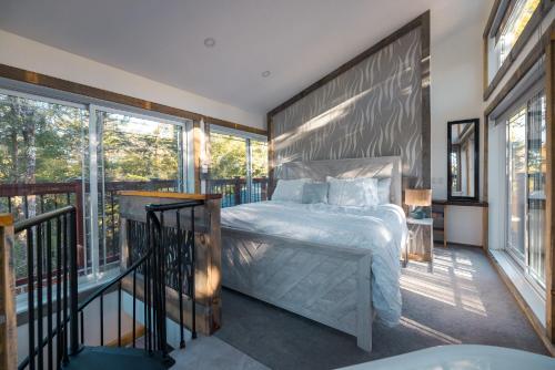 sypialnia z łóżkiem oraz balkon z oknami w obiekcie LoveNest - Hot tub & Fireplace - Warm, cozy & relaxing w mieście Grenville-sur-la-Rouge