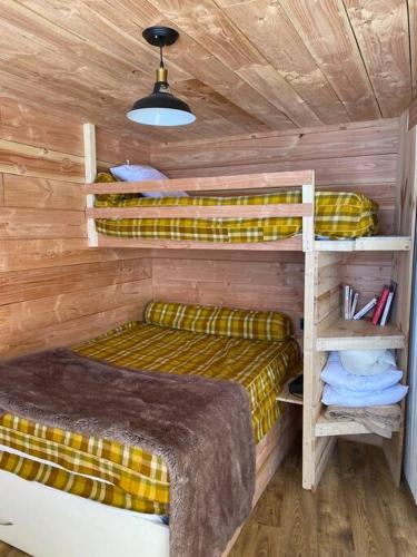 a bedroom with two bunk beds in a cabin at Appartement chalet 4-6 personnes au pied des pistes in Bagnères-de-Bigorre