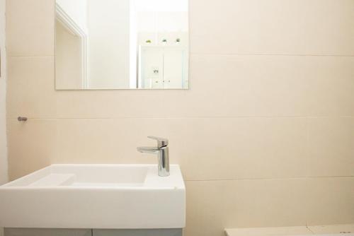 y baño con lavabo blanco y espejo. en 1 Bedroom Baker Street Central Apartment, en Londres