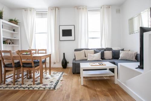 a living room with a blue couch and a table at 1 Bedroom Baker Street Central Apartment in London