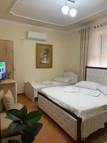 a bedroom with two beds and a tv in it at Aron’s House in Krujë