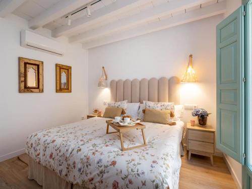 a white bedroom with a bed with a table on it at Villa Glorïa 10PAX Parking free in Granada