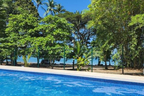 a blue swimming pool with trees in the background at Apartamento hermoso Playa Blanca in Punta Leona