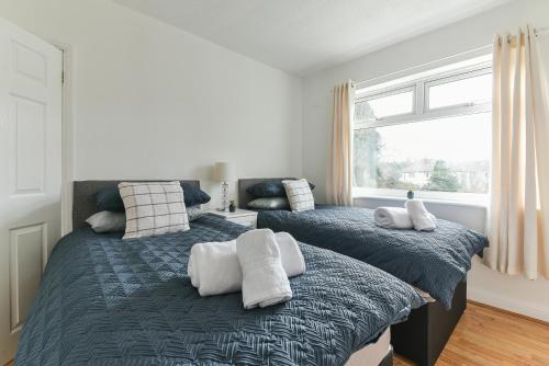 dwa łóżka siedzące obok siebie w sypialni w obiekcie Fabulous 3 Bedroom House Near Black Country Museum Contractors & families w mieście Tipton
