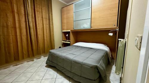 a small bed in a room with a cabinet at Relais Matteotti, fatto per te. in Bologna