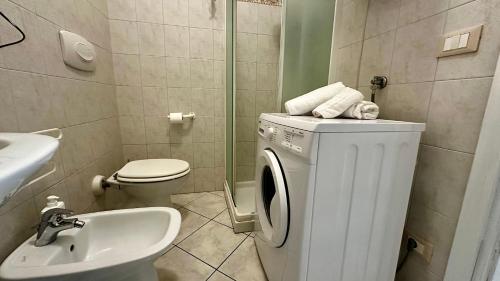 a bathroom with a washing machine and a sink at Relais Matteotti, fatto per te. in Bologna