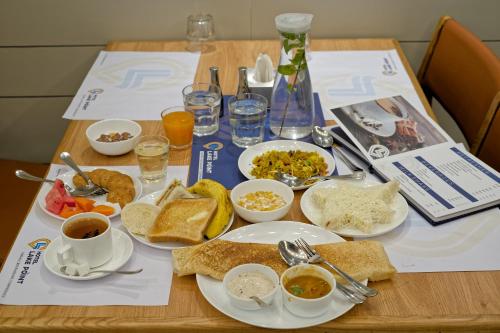 a table topped with plates and bowls of food at Hotel Lake Point in Ahmedabad